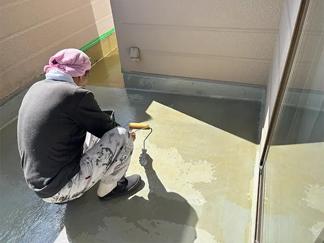 ベランダの床面と、壁際の立ち上がり部分の防水改修を行いました。
ガラス繊維のマットに樹脂を含ませて防水層をつくり、雨水の浸入を防ぎます。
壁との境目や排水口の周辺など、細かな部分までていねいに施工。
グレーの保護塗装で仕上げ、傷みが目立っていた床を、すっきりとした印象に整えました。
